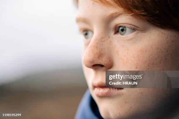 close-up van jongen op zoek weg terwijl overweegt - mouth thinking stockfoto's en -beelden