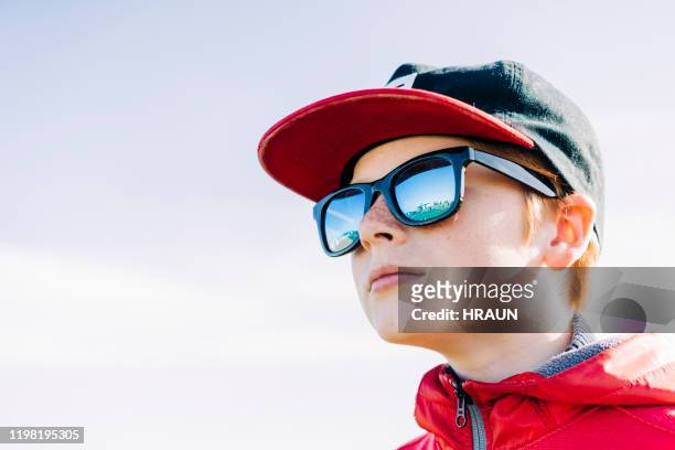 boy wearing sunglasses and cap against clear sky - sunglasses reflection stock pictures, royalty-free photos & images