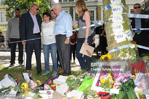 Amy Winehouse's mother Janis Winehouse , brother Alex Winehouse and father Mitch Winehouse look at the floral tributes left outside her Camden Square...