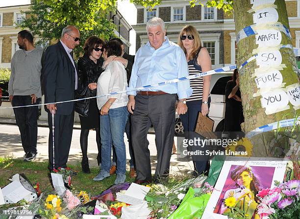 Amy Winehouse's mother Janis Winehouse , brother Alex Winehouse and father Mitch Winehouse look at the floral tributes left outside her Camden Square...