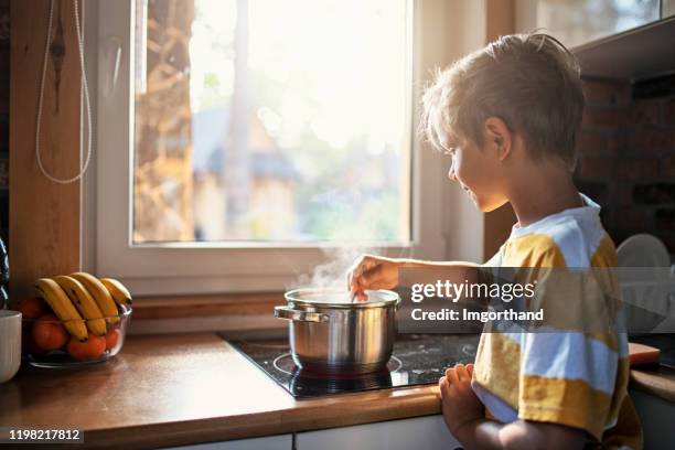 little boy stirring soup in the pot - stirring stock pictures, royalty-free photos & images