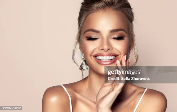 Portrait of beautiful woman with closed eyes and wide, happy toothy smile on the face. Makeup, cosmetic and advertisement.