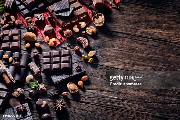 låg nyckelbild av en mängd olika choklad och bomben med torkad frukt. gammaldags stil på ett rustikt bord med kopierings utrymme - bombones chocolate bildbanksfoton och bilder