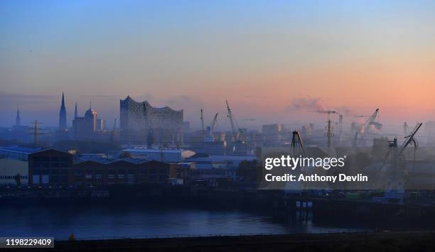 General view of Hamburg including St. Nicholas' Church and the Elbphilharmonie Hamburg concert venue on a misty morning in the Port of Hamburg on...