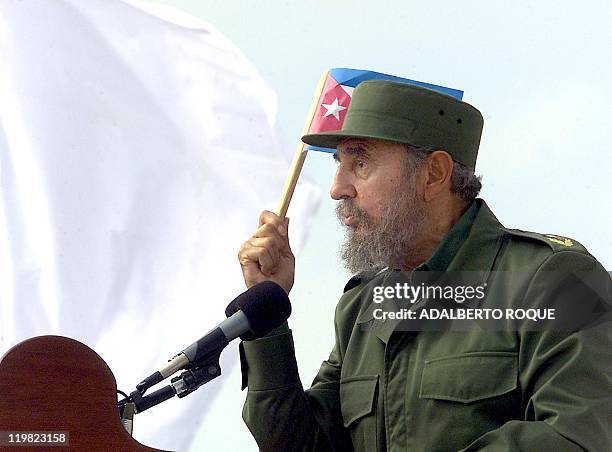 Cuban President Fidel Castro speaks to a crowd, holding a Cuban flag, in Sancti-Spiritus, some 340 km east of Havana, 25 May 2002. Several thousand...