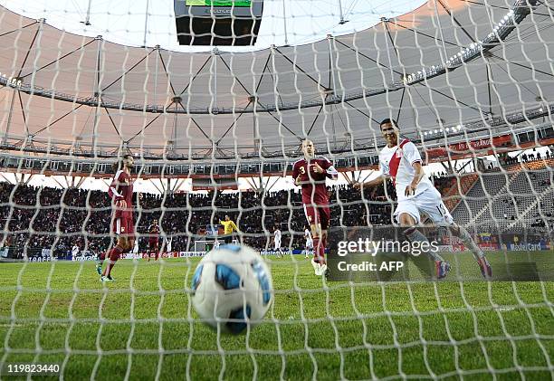 Peruvian forward William Chiroque celebrates after teammate Paolo Guerrero scored, as Venezuelan defenders Oswaldo Vizcarrondo and Jose Manuel Rey...