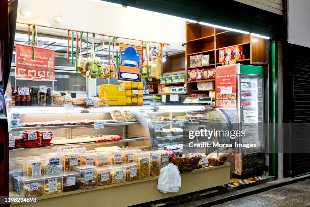 voedsel in verlichte vitrinekast in de winkel - vitrinekast stockfoto's en -beelden