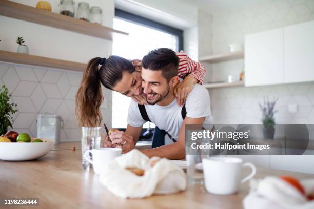 portrait of young affectionate cheerful couple having breakfast indoors at home. - young couple cooking stock pictures, royalty-free photos & images