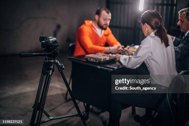 detectives interrogating a male prisoner in interrogation room - probation stock pictures, royalty-free photos & images