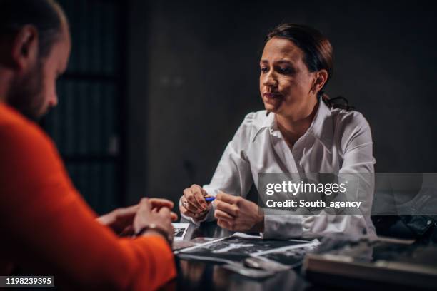 woman detective interrogating a man prisoner in interrogation room - probation stock pictures, royalty-free photos & images