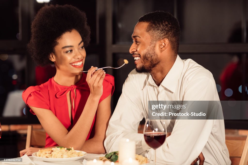Loving Afro Couple Having Date Feeding Each Other In Restaurant