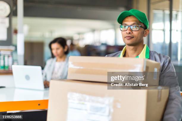 courier collecting or delivering parcels from small business - picking up mail stock pictures, royalty-free photos & images