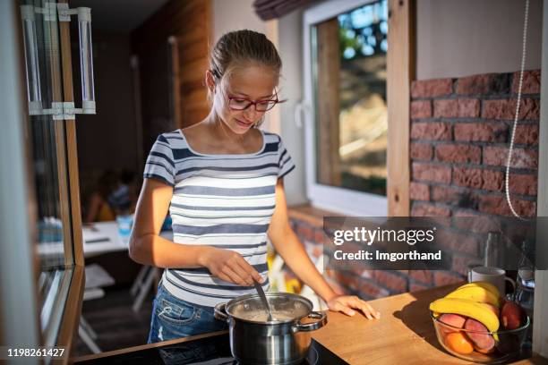 teenage girl stirring soup in the pot - stirring stock pictures, royalty-free photos & images