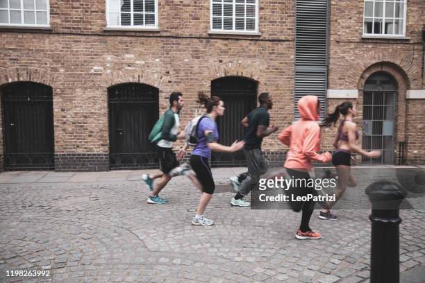 athletic group of urban runner people exercising in london - central london stock pictures, royalty-free photos & images