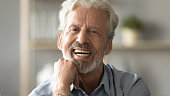 Portrait elderly man with candid wide smile looking at camera