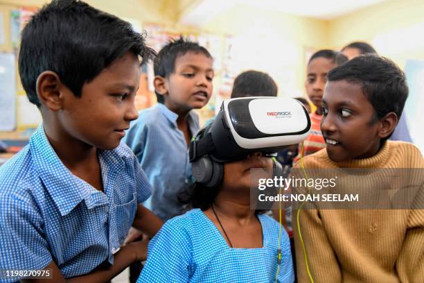 Student tries a virtual reality headset, introduced in the class to increase the students attention span, at a government primary school in...