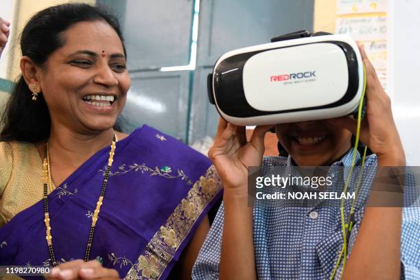 Student tries a virtual reality headset, introduced in the class to increase the students attention span, at a government primary school in...
