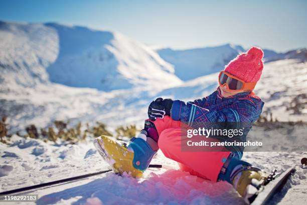 klein meisje houdt haar gewonde enkel op de skipiste - woman in broken shoe heel stockfoto's en -beelden