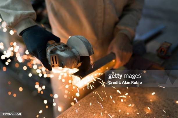 professional bricklayer cutting an iron bar with a cutter while releasing large colored sparks - hand tool stock-fotos und bilder