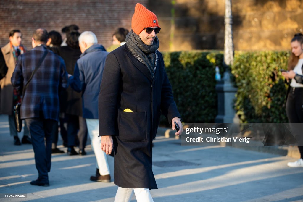 A guest is seen wearing orange beanie during Pitti Uomo 97 at... News ...