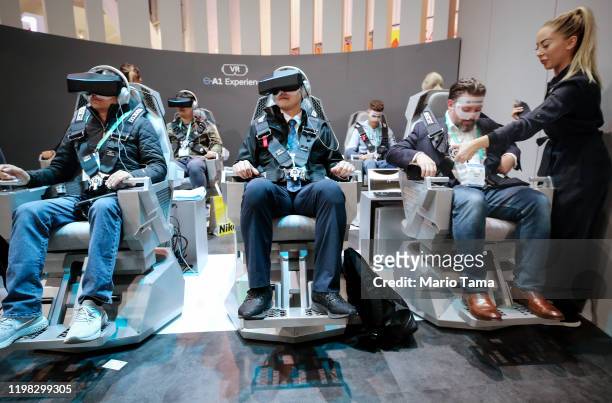 Attendees use virtual reality headsets to experience Hyundai and Uber's air taxi, S-AI, at CES 2020 at the Las Vegas Convention Center on January 8,...