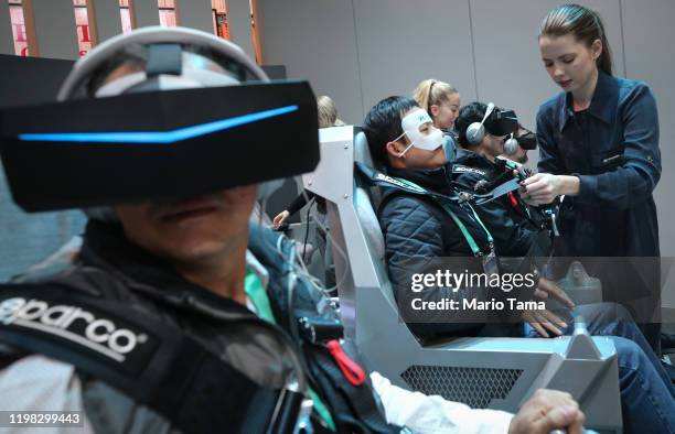 Attendees use virtual reality headsets to experience Hyundai and Uber's air taxi, S-AI, at CES 2020 at the Las Vegas Convention Center on January 8,...