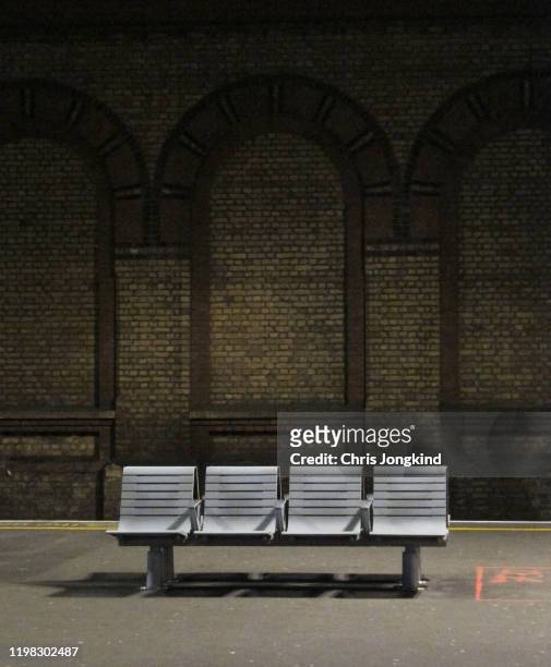bench on platform against brick wall - train platform stock pictures, royalty-free photos & images
