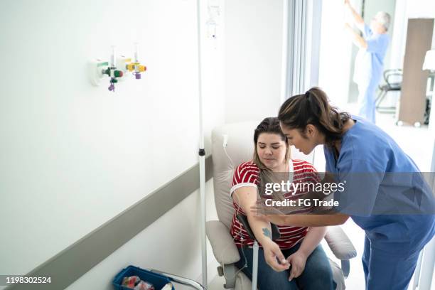 mulheres recebem tratamento de gotejamento intravenoso - infused - fotografias e filmes do acervo