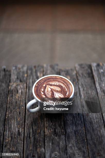 deliziosa cioccolata calda con arte della schiuma in cima al tavolo di legno - chocolate bar foto e immagini stock