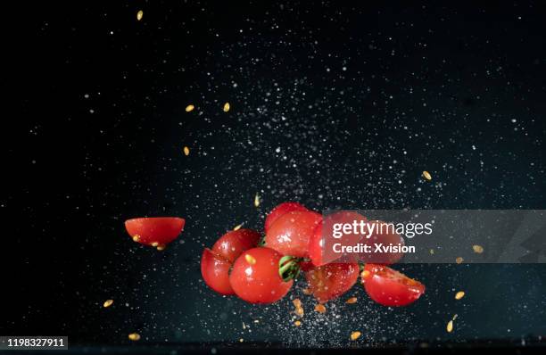 cherry tomato flying in mid air with white powder"n - tomato smash stock pictures, royalty-free photos & images