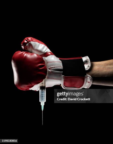 boxing glove holding a syringe - steroids stock pictures, royalty-free photos & images