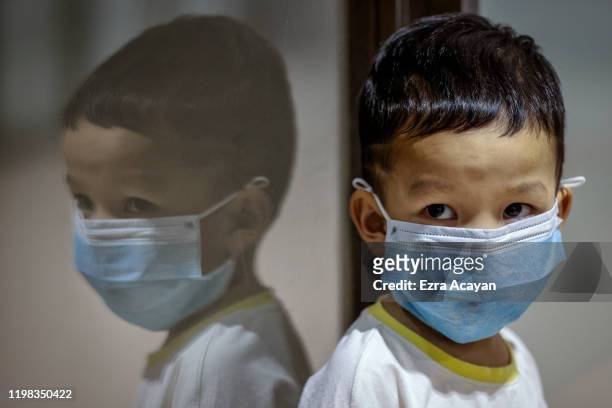 Child is seen wearing a facemask, as public fear over China's Wuhan Coronavirus grows, at the Ninoy Aquino International Airport on February 3, 2020...