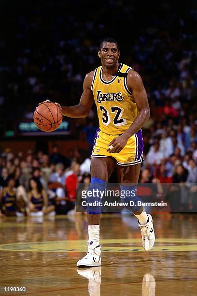 Magic Johnson of the Los Angeles Lakers moves the ball upcourt during an NBA game at the Forum in Los Angeles, California. NOTE TO USER: User...