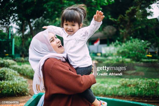 doting mother with daughter - malay hijab stock pictures, royalty-free photos & images