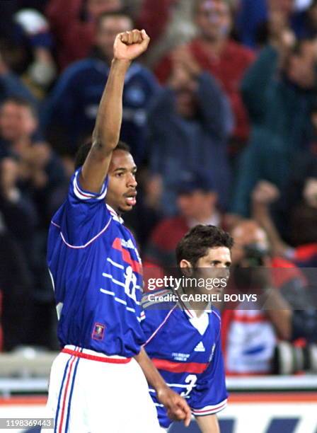 French forward Thierry Henry raises his fist after scoring the third and last goal for his team as teammate Bixente Lizarazu looks on, 12 June at...