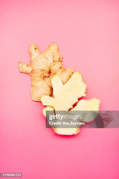 high angle view of a halved ginger root on pink background - gember stockfoto's en -beelden