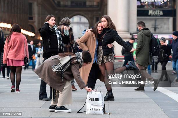 This picture taken in Milan from the Duomo square on February 3,2020 shows tourists posing for a picture at the entrance of the Vittorio Emanuele II...