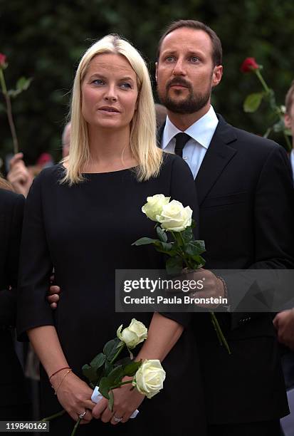 Norway's Crown Princess Mette-Marit and Crown Prince Haakon listen to music as hundreds of thousands of people gather at a memorial vigil following...