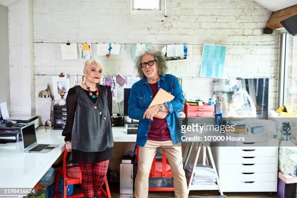 portrait of senior couple in creative home office - creative director stock pictures, royalty-free photos & images