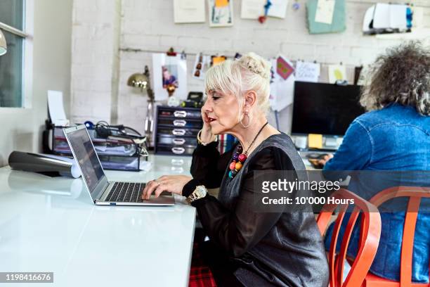 senior woman working on laptop in home office - creative director stock pictures, royalty-free photos & images
