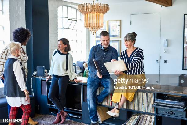 mature friends at social gathering looking at records - disability collection stock pictures, royalty-free photos & images