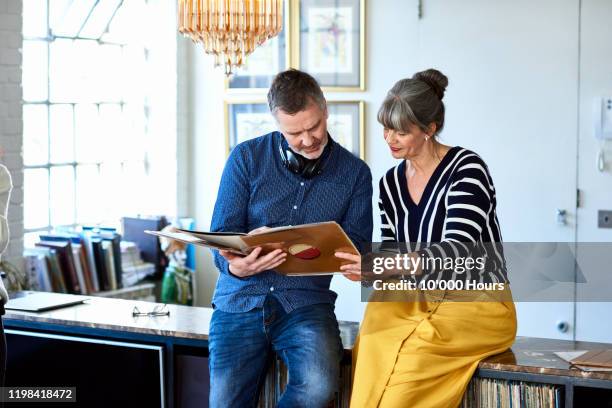 portrait of mature couple looking at vinyl record - the life picture collection foto e immagini stock