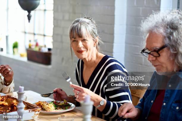 mature woman enjoying healthy lunch with friends - senior men eating stock pictures, royalty-free photos & images