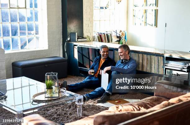 mature male friends listening to records at home - the life picture collection stock-fotos und bilder