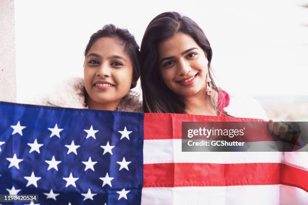 chica sosteniendo la bandera americana celebrando la independencia - feliz 4 de julio - expatriado fotografías e imágenes de stock