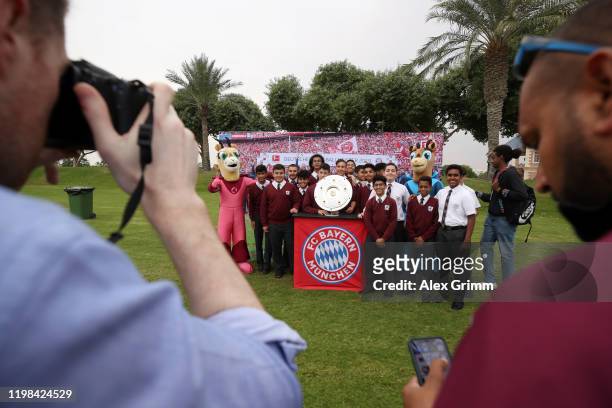 Fans pose with the German Bundesliga trophy during a training session on day six of the FC Bayern Muenchen winter training camp on January 09, 2020...