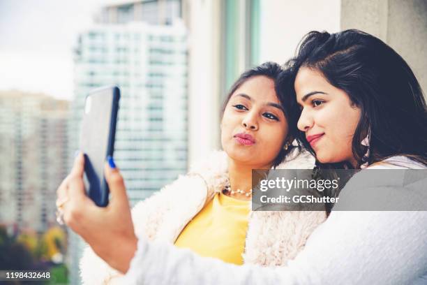 girlfriends taking selfie at the balcony using smartphone - mississauga stock pictures, royalty-free photos & images