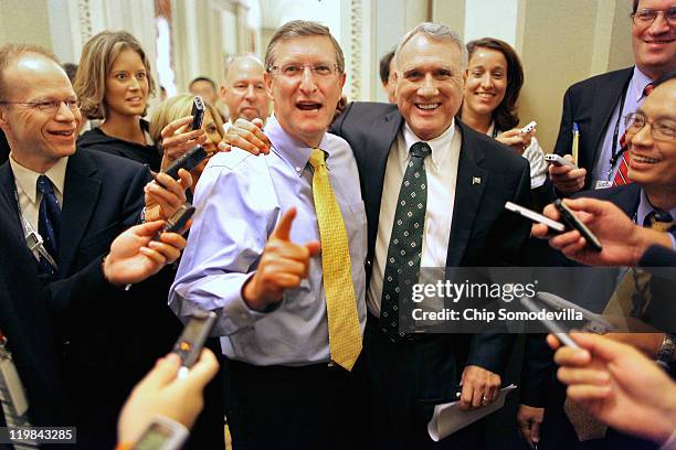 Surrounded by reporters, Senate Budget Committee Chairman Sen. Kent Conrad and Senate Minority Whip Sen. Jon Kyl embrace and share a laugh after...