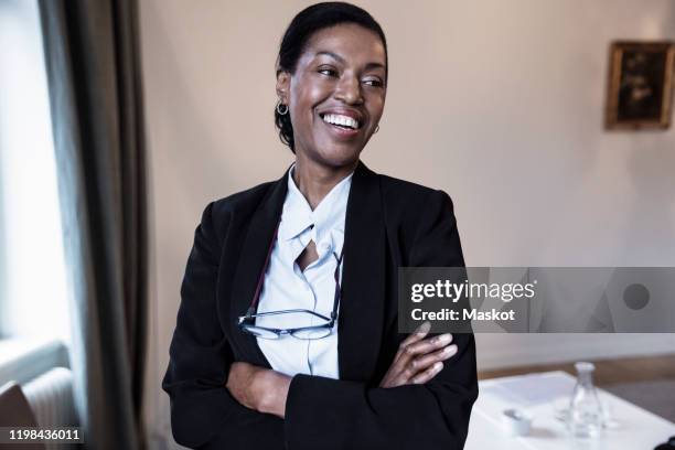 smiling female law professional with arms crossed standing at law firm - legal expertise stock pictures, royalty-free photos & images