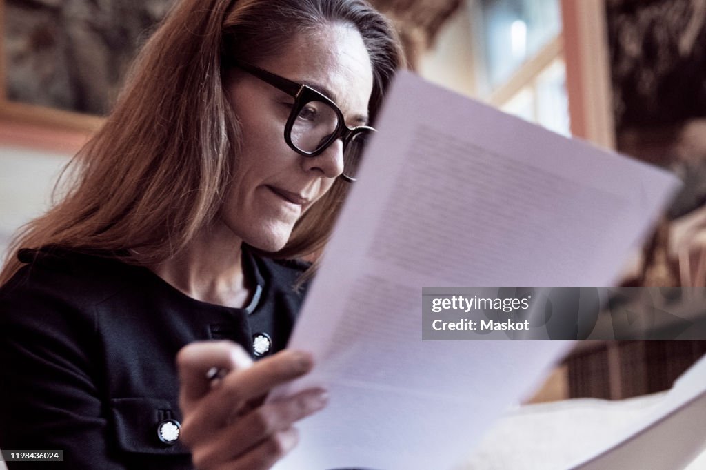 Low angle view of female professional analyzing documents at law firm